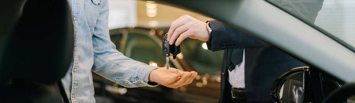 Close up of keys being handed over to a new car owner