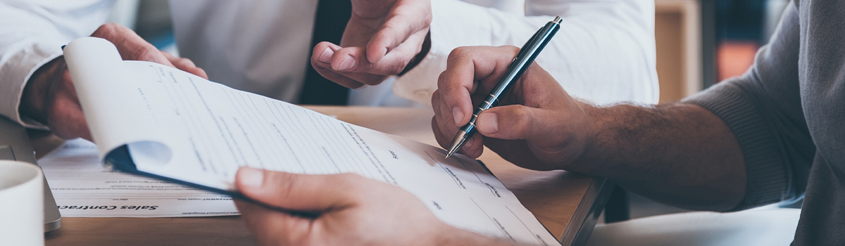 two people at desk filling out form 