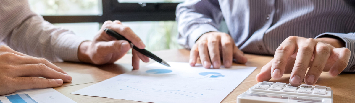 Banker showing a customer a chart on a desk with a calculator